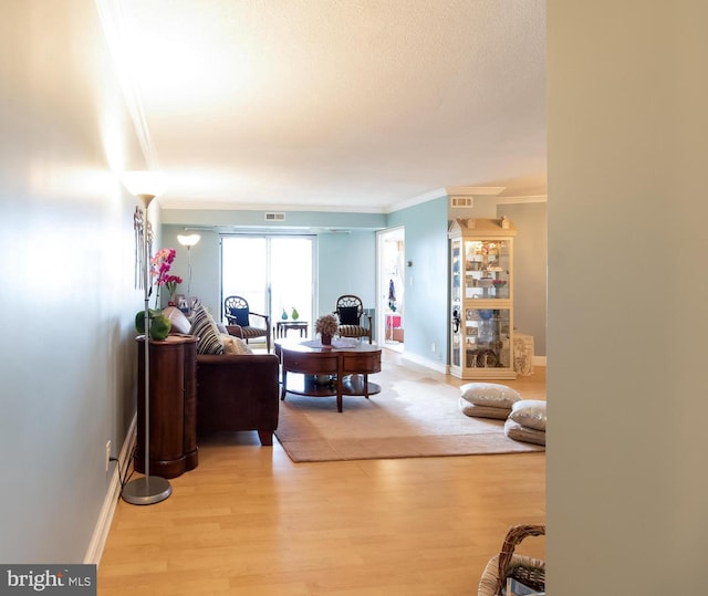 living room with light hardwood / wood-style floors and crown molding