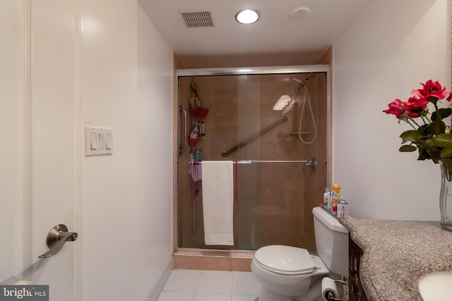 bathroom with tile floors, a shower with door, vanity, and toilet