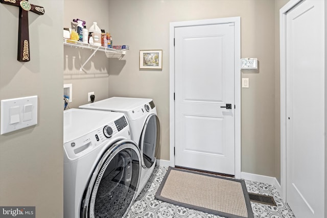 clothes washing area featuring washer hookup, tile flooring, washer and clothes dryer, and electric dryer hookup