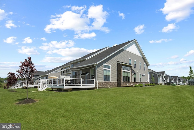 back of house featuring a yard and a deck