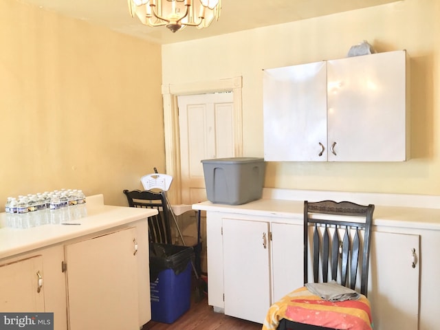 laundry area with dark hardwood / wood-style floors and an inviting chandelier