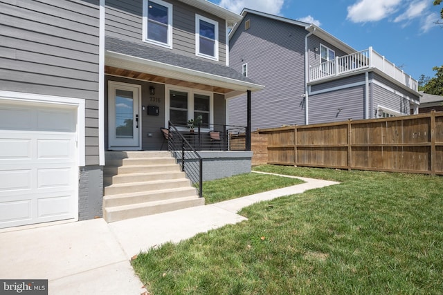 doorway to property featuring a lawn, covered porch, and a garage