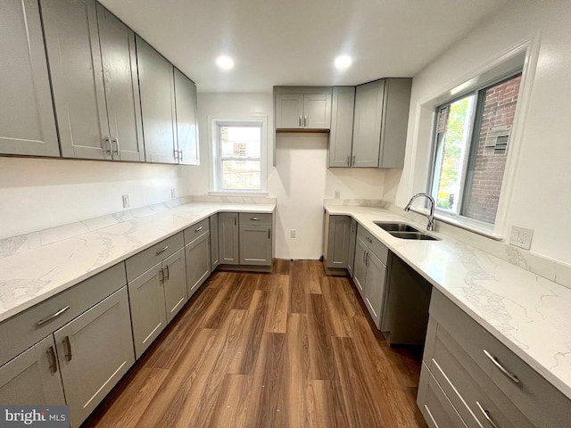 kitchen with gray cabinets, light stone counters, dark hardwood / wood-style floors, and sink