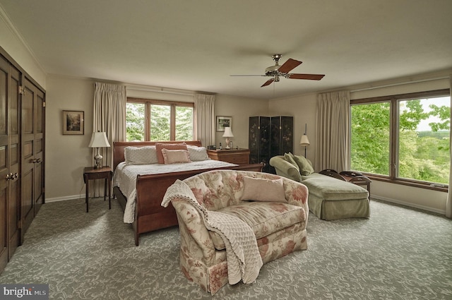 bedroom with crown molding, a closet, ceiling fan, and dark carpet