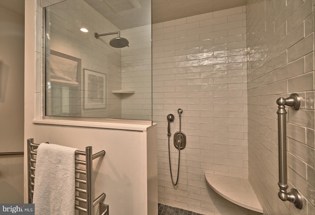 bathroom featuring a tile shower and radiator heating unit