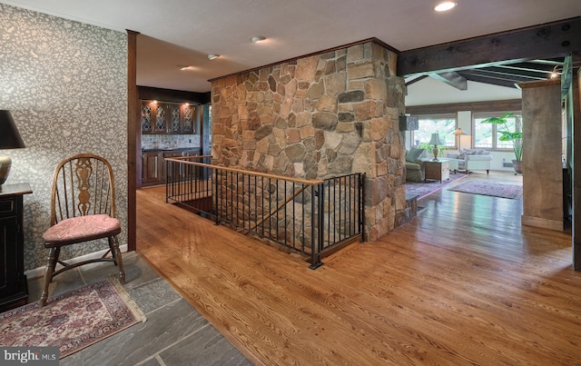 corridor featuring beamed ceiling and hardwood / wood-style floors