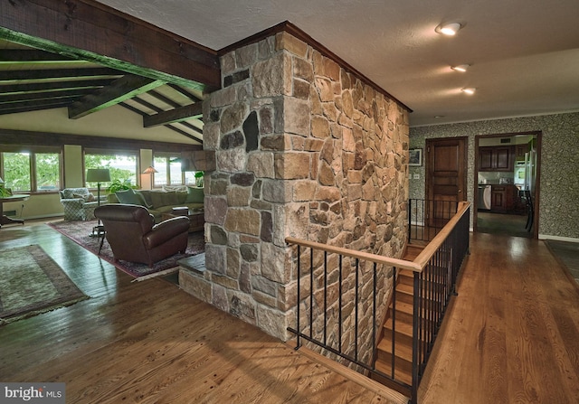 corridor featuring lofted ceiling with beams, a textured ceiling, and wood-type flooring