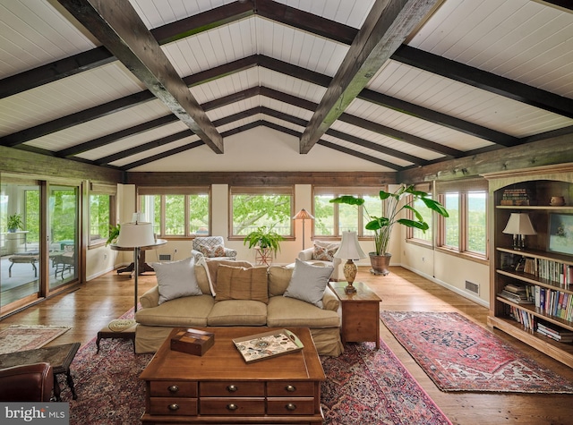 living room featuring hardwood / wood-style flooring, plenty of natural light, and vaulted ceiling with beams