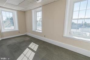 unfurnished room featuring a drop ceiling