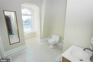 bathroom featuring tile flooring, vanity, and toilet