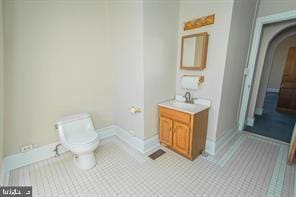 bathroom with tile flooring, toilet, and vanity