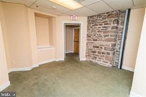 carpeted spare room with a drop ceiling