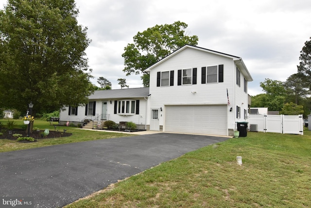 view of front of house featuring cooling unit, a garage, and a front lawn