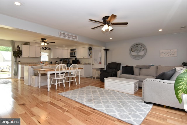 living room with ceiling fan and light hardwood / wood-style floors