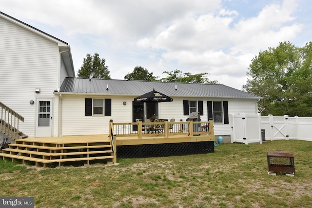 rear view of house with a yard and a deck