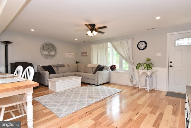 living room featuring light hardwood / wood-style flooring and ceiling fan