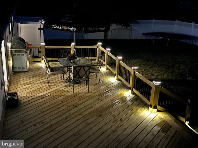 deck at night featuring a trampoline