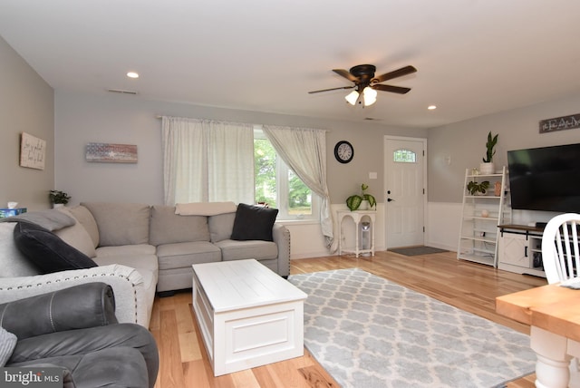 living room with light hardwood / wood-style flooring and ceiling fan