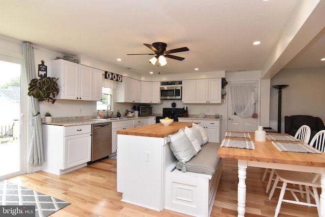 kitchen featuring a wealth of natural light, white cabinetry, and appliances with stainless steel finishes