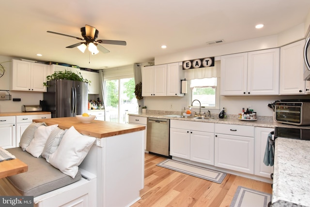 kitchen with a healthy amount of sunlight, white cabinetry, and appliances with stainless steel finishes