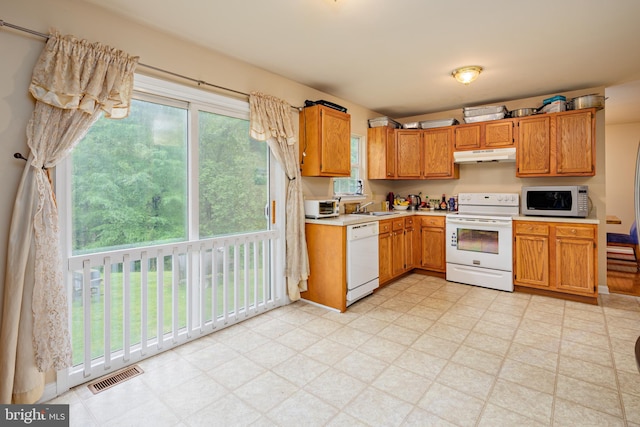 kitchen with white appliances, sink, and light tile floors