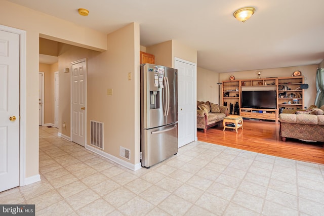 kitchen with light tile flooring and stainless steel fridge with ice dispenser