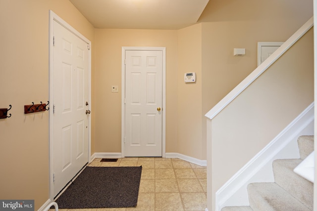 foyer entrance with light tile flooring