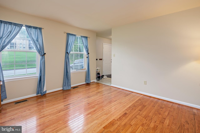 spare room with light hardwood / wood-style flooring and a wealth of natural light