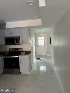 kitchen featuring appliances with stainless steel finishes, light tile floors, and gray cabinets