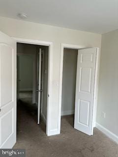 unfurnished bedroom with dark carpet