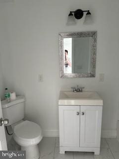 bathroom featuring tile flooring, toilet, and vanity