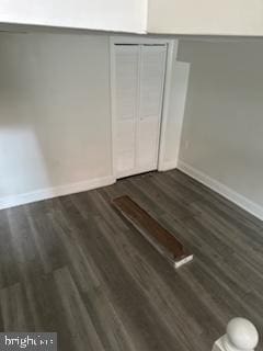 unfurnished bedroom featuring dark wood-type flooring and a closet