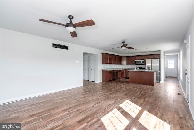 kitchen with ceiling fan, dark hardwood / wood-style floors, a center island, and appliances with stainless steel finishes