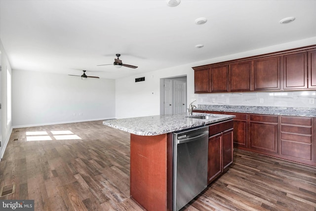 kitchen with sink, dark hardwood / wood-style flooring, stainless steel dishwasher, and an island with sink