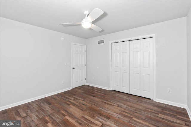 unfurnished bedroom featuring dark hardwood / wood-style flooring, a closet, and ceiling fan