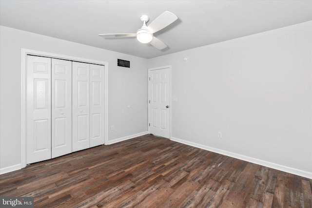 unfurnished bedroom featuring ceiling fan, a closet, and dark wood-type flooring