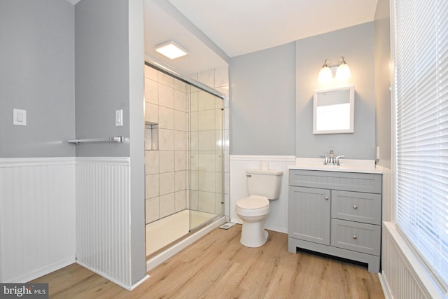 bathroom with an enclosed shower, large vanity, toilet, and wood-type flooring