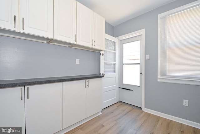 kitchen featuring light hardwood / wood-style floors, a wealth of natural light, and white cabinetry