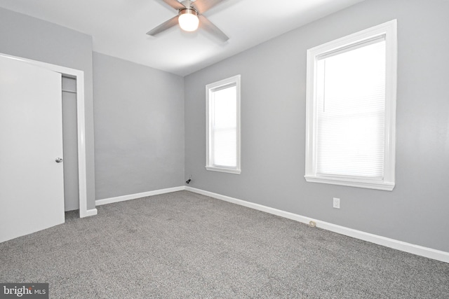 carpeted spare room featuring ceiling fan