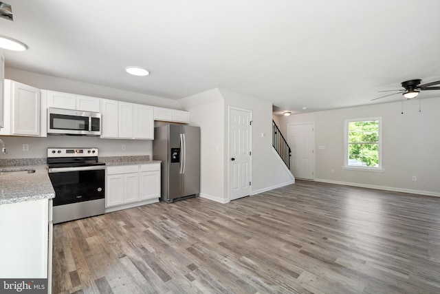 kitchen featuring stainless steel appliances, sink, white cabinetry, and hardwood / wood-style flooring