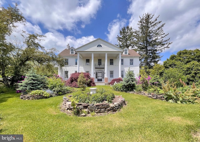 greek revival inspired property featuring a front lawn