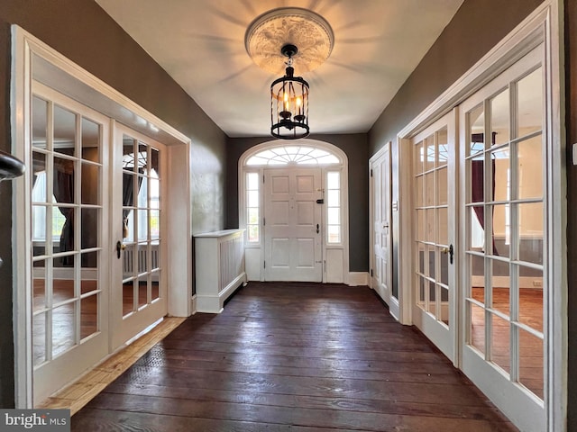 entryway featuring dark hardwood / wood-style flooring, french doors, and a notable chandelier