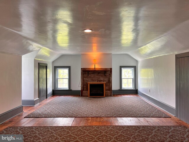 unfurnished living room featuring lofted ceiling and hardwood / wood-style flooring