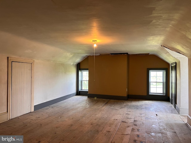 bonus room with vaulted ceiling and light hardwood / wood-style floors