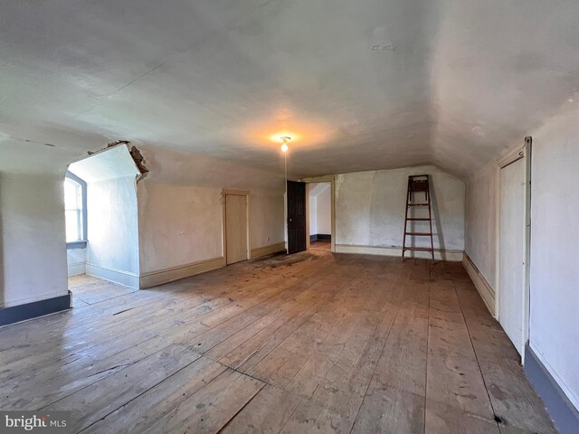 additional living space featuring lofted ceiling and hardwood / wood-style floors