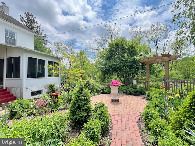 view of yard featuring a sunroom, a pergola, and a patio area