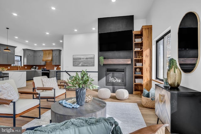 living room with recessed lighting, a fireplace, and light wood-style floors