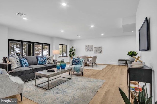 living room featuring recessed lighting, visible vents, light wood-style flooring, and baseboards