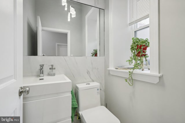 bathroom with decorative backsplash, vanity, and toilet