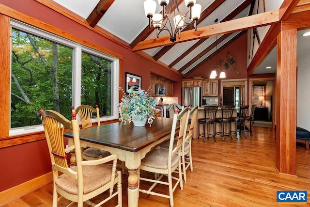 dining room featuring beamed ceiling, a notable chandelier, high vaulted ceiling, and light wood-type flooring